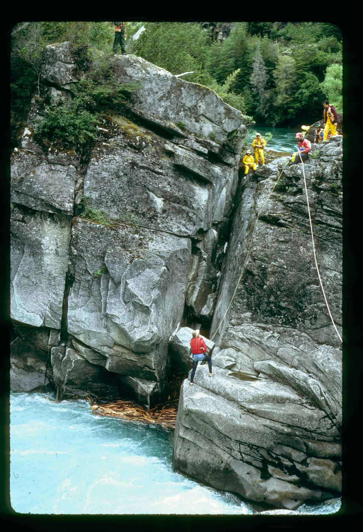 To safely run the rafts through Zeta, Danny Bolster rappelled down to this rock where he could rescue any boats that strayed into the keeper eddy (lower left of photo). Note driftwood stuck in the eddy. Two of our boats did go into the eddy and were rescued by Dan | Photo by Brad Lord