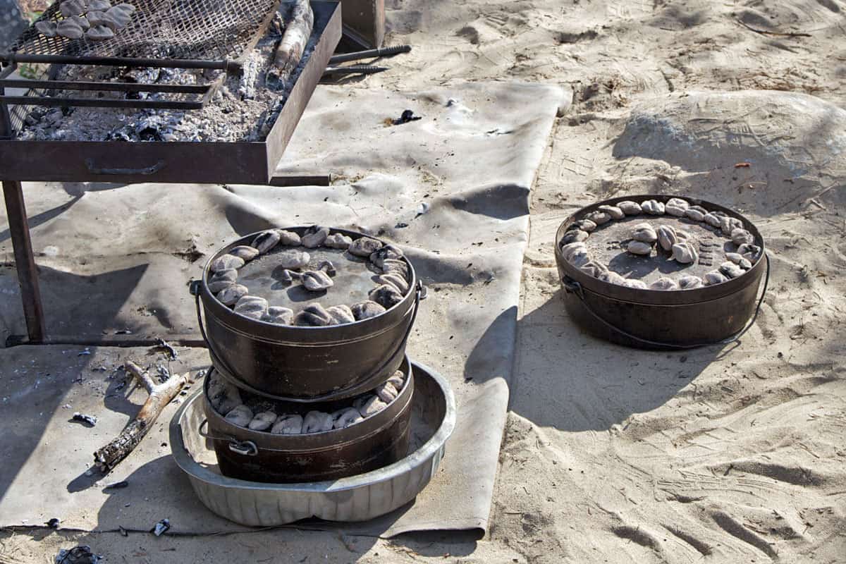 Dutch Ovens baking with charcoal. They can be single or stacked.