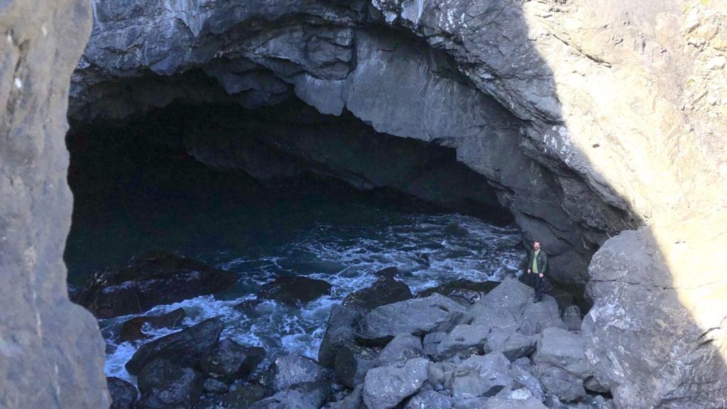 Chris Looking into the Sea Cave at Sisters Rock