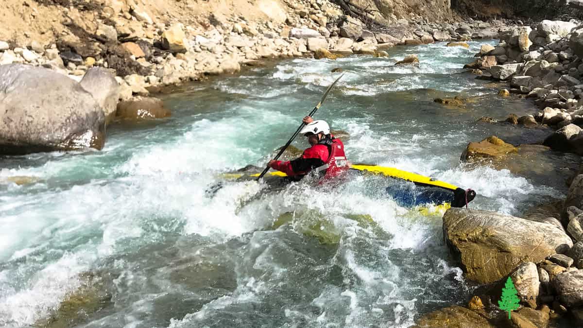 Inflatable kayak pinned (or wrapped) on a rock