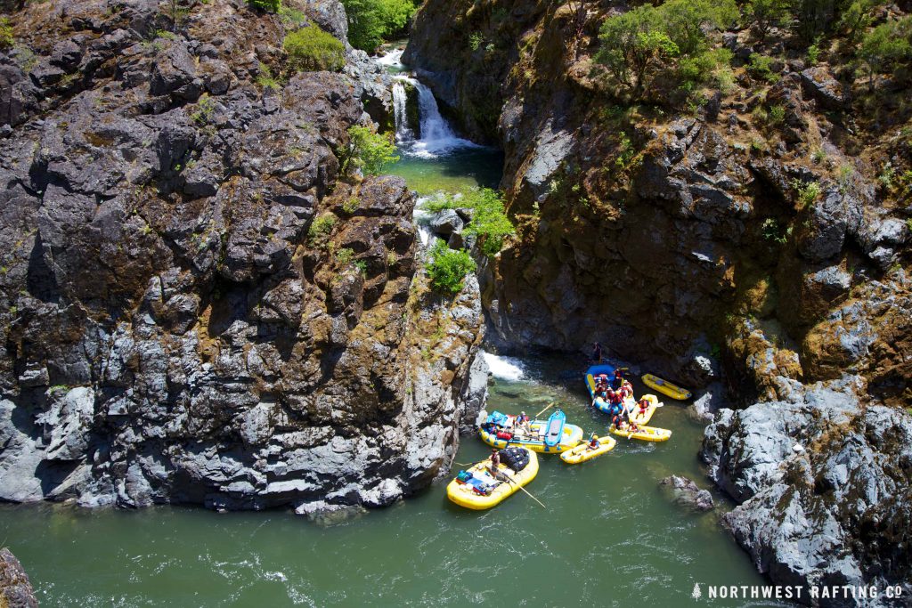 waterfall into canyon, river, rafts