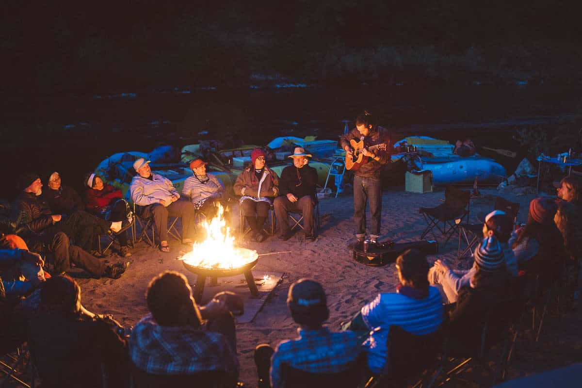 Jenner playing music around an evening campfire