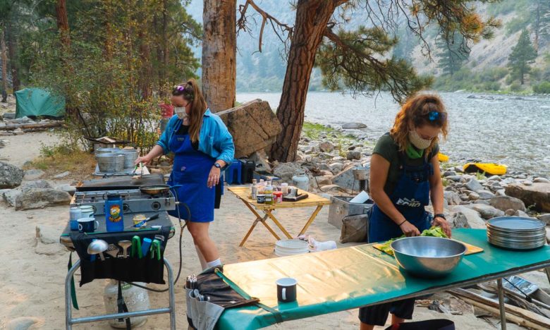 Taking COVID precautions while making dinner on a rafting trip